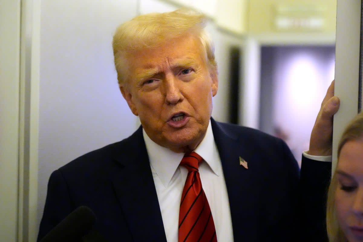 President Donald Trump speaks to reporters aboard Air Force One. His administration has issued a freeze on all government loans and grants (AP)